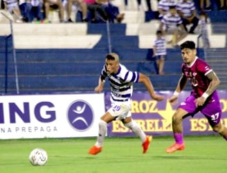 El juvenil Claudio Escobar se escapa de la marca de Matías Espinoza en el partido entre 2 de Mayo y Libertad.
