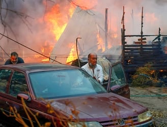 Vecinos empujando un automóvil alejándose de un incendio forestal que arrasa viviendas en Villa Alemana, Valparaíso, Chile. 2 de febrero de 2024.