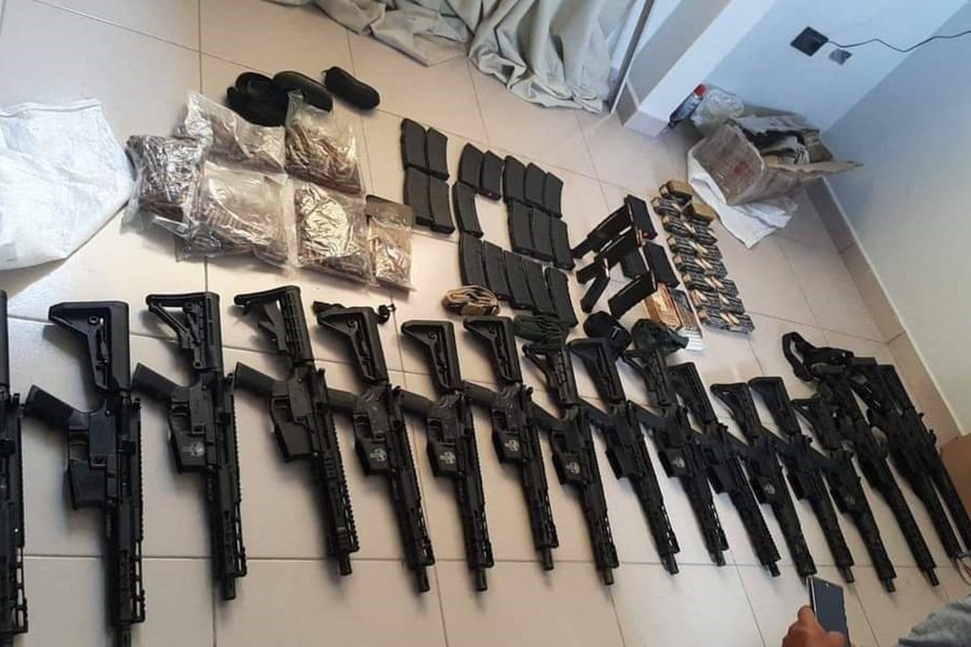 This handout picture released by the Bolivian Ministry of Government shows weaponry and drugs seized from a house searched by anti-narcotics police during an operation to try to arrest Uruguayan Sebastian Marset in Santa Cruz, Bolivia, on July 30, 2023. Bolivia has mobilized more than 2,250 security agents for a manhunt of a wanted cocaine trafficker who has ricocheted around the world to elude capture, a senior official said on Sunday. The target of the hunt is Sebastian Enrique Marset Cabrera, wanted on drugs charges in his native Uruguay, Paraguay, Brazil and the United States. (Photo by Handout / Bolivian Ministry of Government / AFP) / RESTRICTED TO EDITORIAL USE - MANDATORY CREDIT "AFP PHOTO / BOLIVIAN MINISTRY OF GOVERNMENT" - NO MARKETING NO ADVERTISING CAMPAIGNS - DISTRIBUTED AS A SERVICE TO CLIENTS