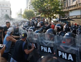 Manifestantes se enfrentan a la policía durante una protesta contra el proyecto de la 'ley ómnibus' a las afueras del Congreso, hoy, en Buenos Aires (Argentina). EFE/ Juan Ignacio Roncoroni