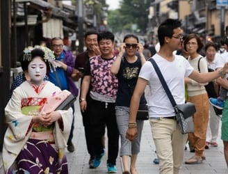 Un grupo de turistas siguen a una geisha por las calles de Kyoto Bloomberg / Getty