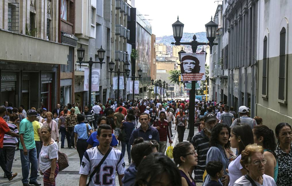 Gente caminando en una calle peatonal en Caracas. AFP.