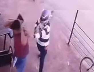 Momento en que uno de los asaltantes encañona con un arma de fuego al trabajador del local. Foto: captura de video.