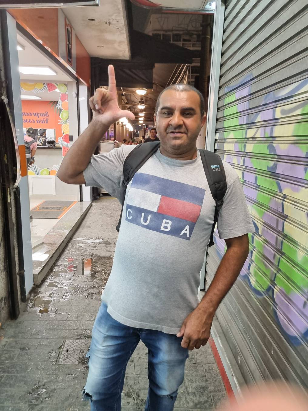 Un trabajador informal de Sao Paulo hace la señal de la inicial de Lula. Foto: Juan Carlos dos Santos.