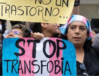 Miembros de grupos LGBTQ+ protestan frente al Ministerio de Salud contra un nuevo decreto gubernamental que cataloga el transexualismo como “trastorno mental” en Lima, el 17 de mayo de 2024, durante el Día Internacional contra la Homofobia, la Transfobia y la Bifobia. © Cris BOURONCLE / AFP