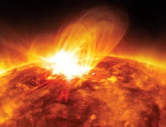 Imagen de una llamarada solar en el lado izquierdo del Sol.