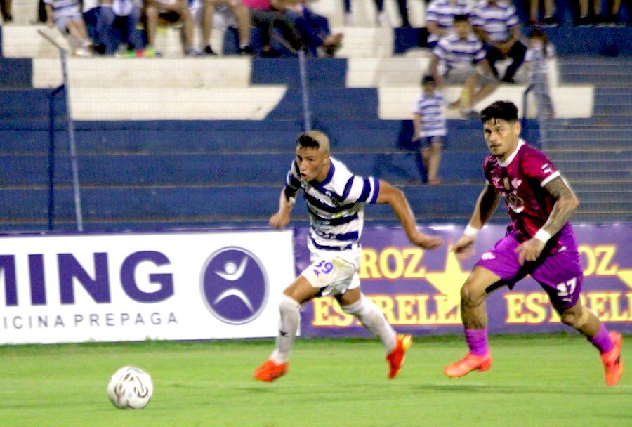 El juvenil Claudio Escobar se escapa de la marca de Matías Espinoza en el partido entre 2 de Mayo y Libertad.