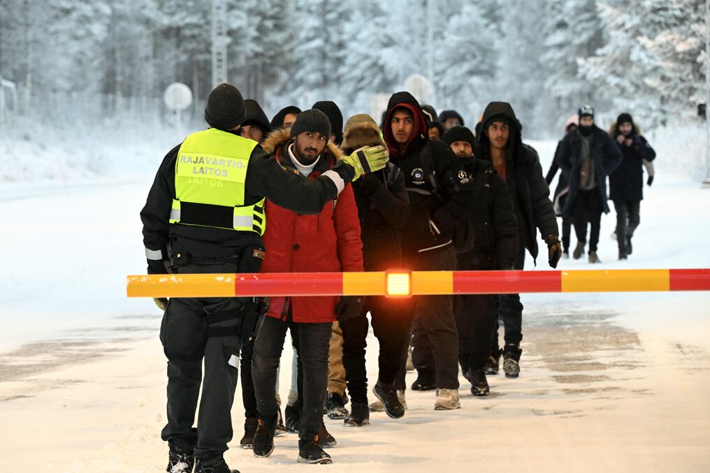 Un guardia fronterizo finlandés habla con migrantes en el cruce fronterizo internacional de Salla, al norte de Finlandia, el 23 de noviembre. Foto: AFP