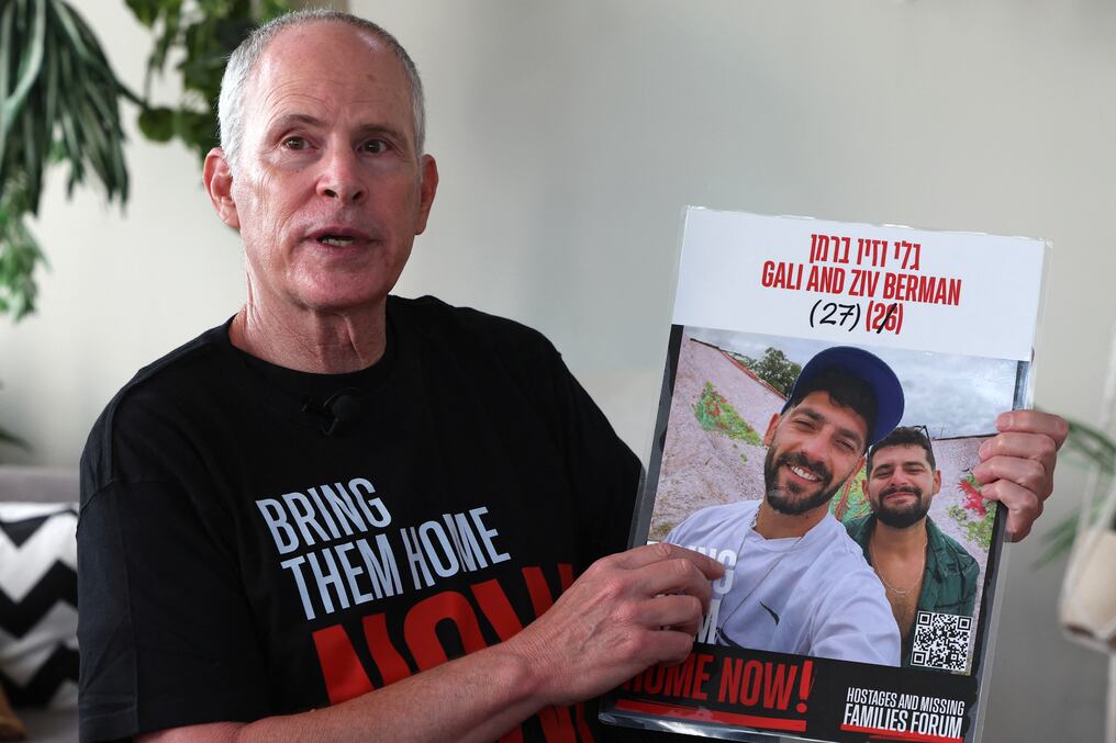 Keith Siegel, de 66 años, señala una foto de los rehenes Gali y Ziv Berman, con quienes estuvo cautivo en Gaza. Foto: Jack Guez/AFP