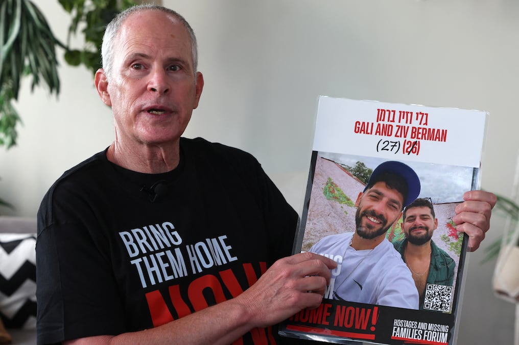 Keith Siegel, de 66 años, señala una foto de los rehenes Gali y Ziv Berman, con quienes estuvo cautivo en Gaza. Foto: Jack Guez/AFP