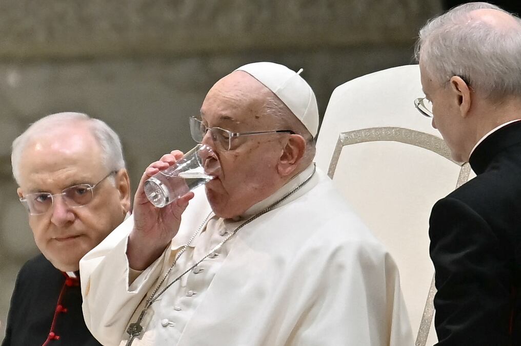 El sacerdote argentino bebe un vaso de agua durante la audiencia general semanal del 12 de febrero. Foto: Filippo Monteforte/AFP