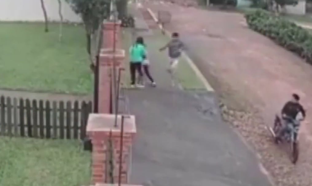 Una de las menores lanzó su teléfono celular a la casa del vecino, mientras que la niña que la sujetaba de la mano sale corriendo. Foto: Gentileza