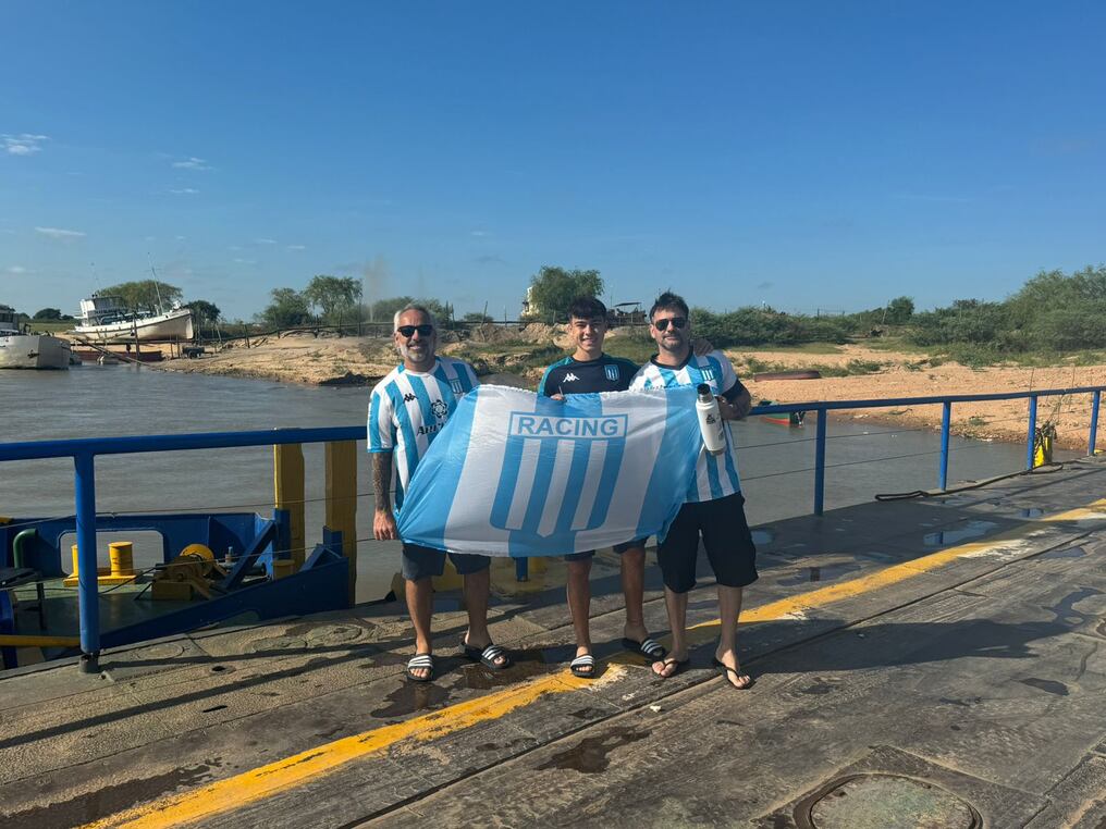 Hinchas del Racing Club cruzando por balsas en zona de Itá Enramada. Foto: Gentileza