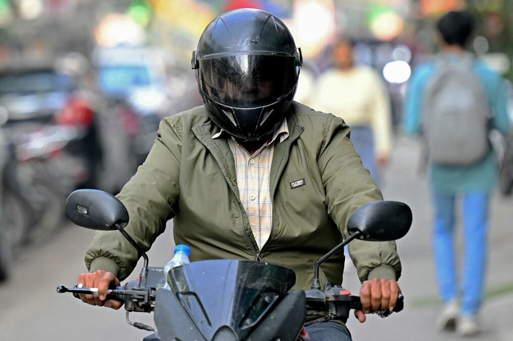 Un detective privado conduce una motocicleta para realizar una misión en Nueva Delhi. Foto: Money Sharma/AFP