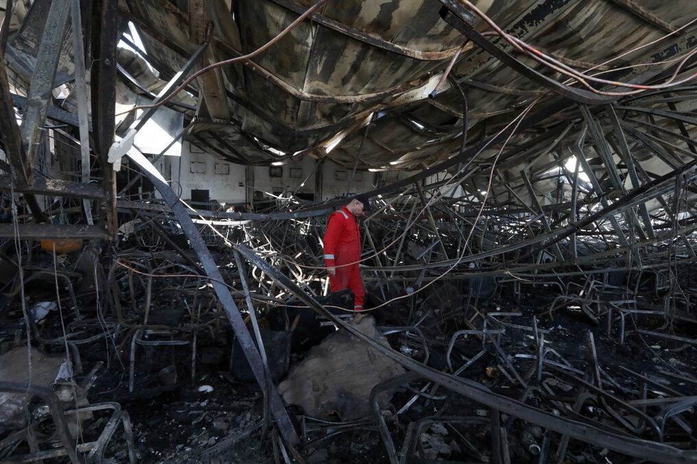 Un bombero comprueba los daños en un salón de eventos en Karakosh, donde un incendio mató al menos a 100 personas e hirió a más de 150. Foto: AFP