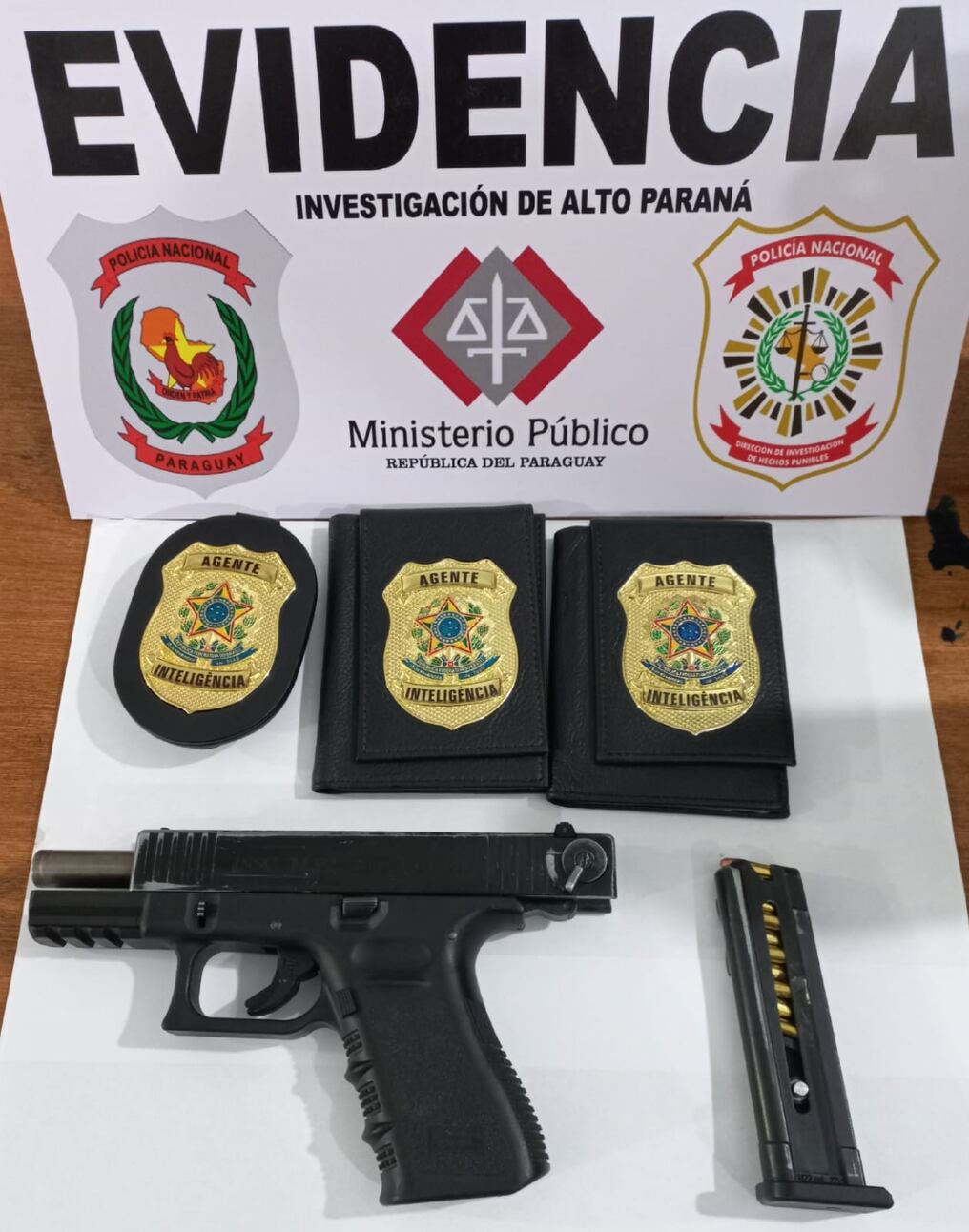 El arma de fuego, el cargador, la placa policial y las dos billeteras con la inscripción de Agente de Inteligencia fueron incautados al ciudadano detenido anoche en la vía pública, por supuesta violación de la Ley de Armas. Foto: Gentileza