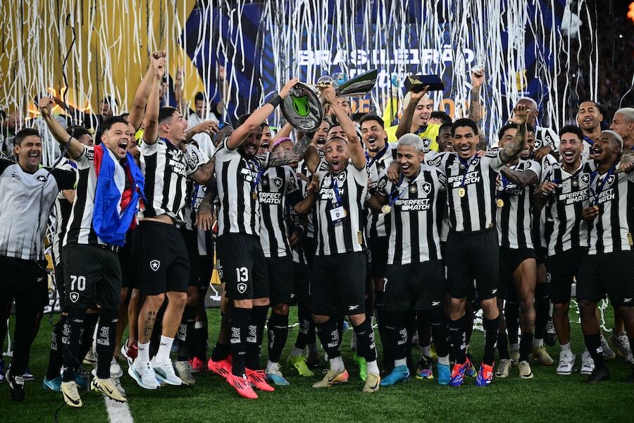 Óscar Romero (con bandera paraguaya al cuello) aparece en primer plano al momento de la entrega del trofeo a los jugadores del Botafogo.FOTO: AFP