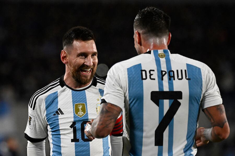 Lionel Messi y su sonrisa pícara junto a De Paul, tras su obra maestra de tiro libre.FOTO:AFP