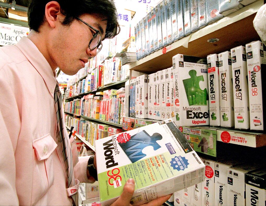 Un empleado de una tienda de informática revisa el inventario de software de Microsoft en Tokio. Foto: Yoshikazu Tsuno/AFP