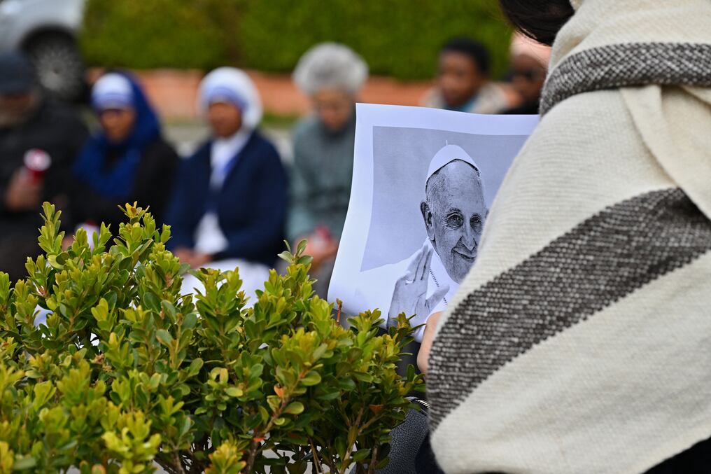 Un fiel sostiene una imagen del papa Francisco durante las oraciones afuera del Hospital Gemelli. Foto: Andreas Solaro/AFP