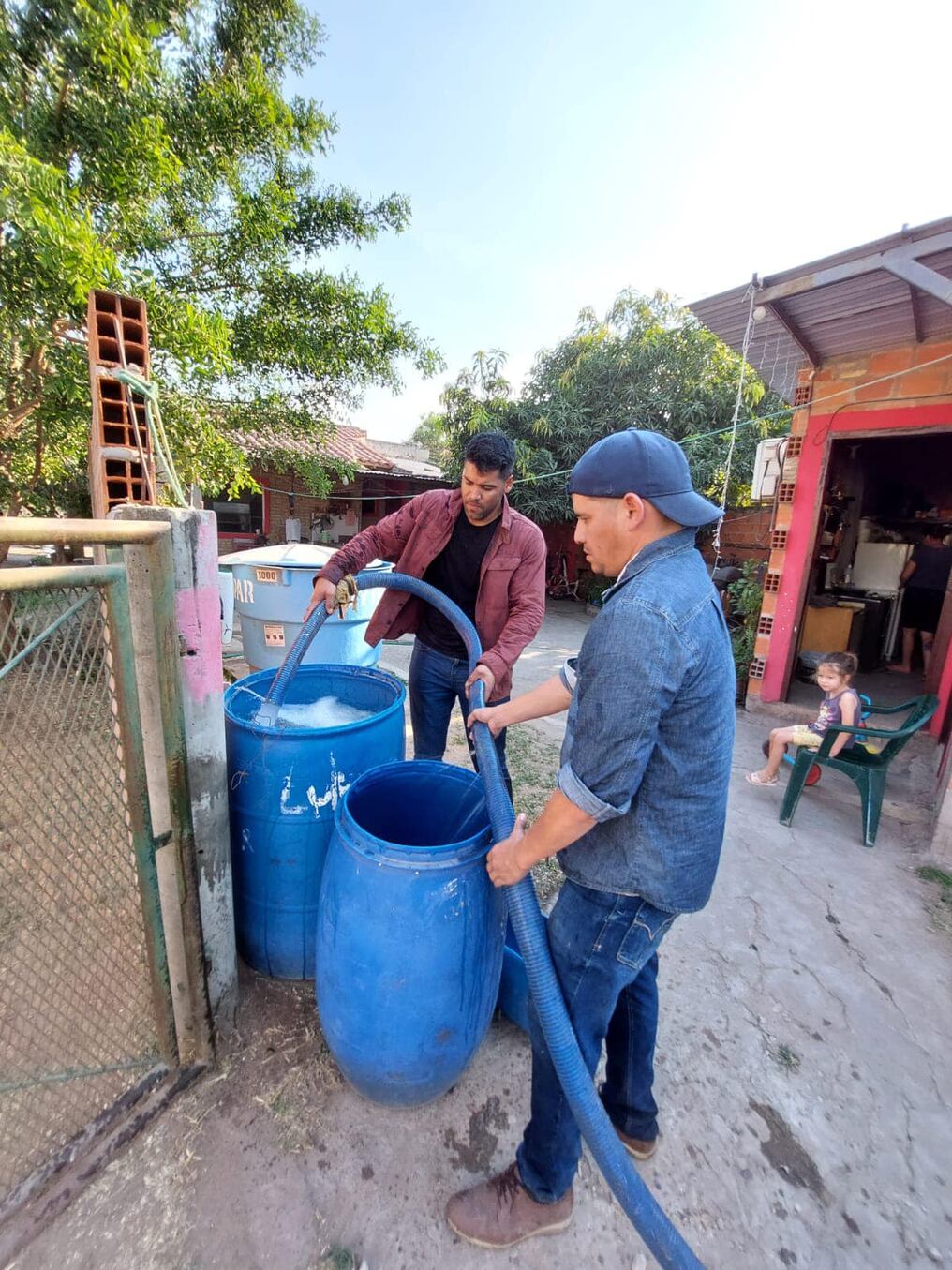El concejal Ricardo "Negro" Núñez (izq.) gestionó la provisión de agua por parte de la Essap, para sectores vulnerables de la localidad de Villa Hayes. Foto: Gentileza