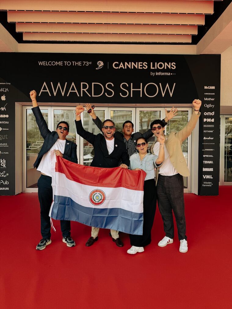 El staff de Oniria celebra con la bandera paraguaya, en Cannes. Foto: Gentileza