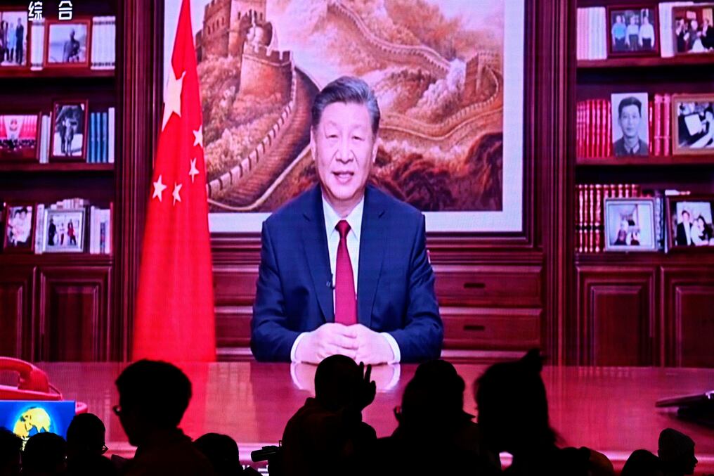 La gente cena en un restaurante mientras una pantalla transmite al mandatario Xi Jinping en su discurso de Año Nuevo en Beijing. Foto: AFP