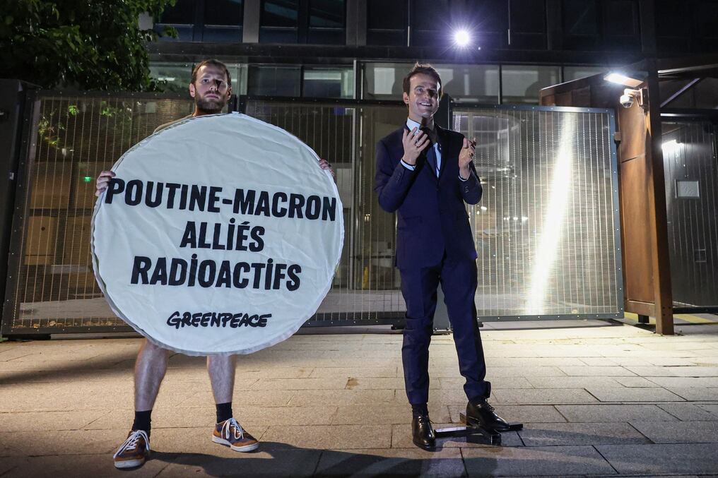 Un activista ambiental sostiene un cartel que dice "Poutine-Macron, aliados radiactivos" junto a la estatua robada del Museo Grevin. Foto: Xavier Galiana/AFP