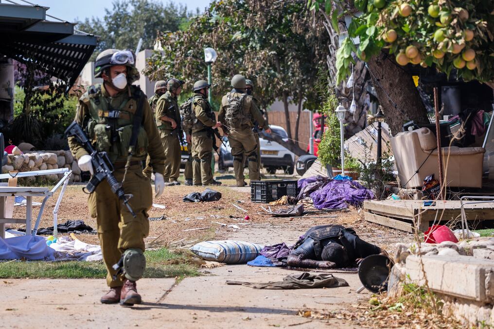 Soldados israelíes se encuentran cerca del cuerpo de un militante palestino en Kfar Aza, en el sur de Israel, en la frontera con la Franja de Gaza, el 10 de octubre de 2023. Foto: AFP