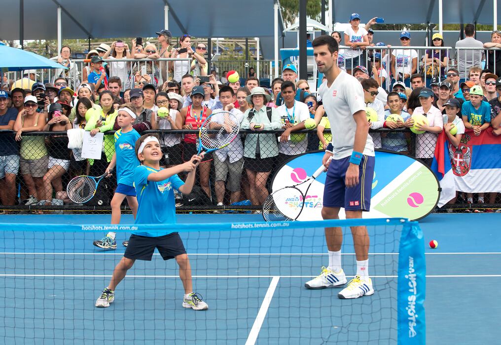 Novak Djokovic interactúa con un joven tenista en el segundo día del Australian Open. Foto:  AFP  / FIONA HAMILTON /
