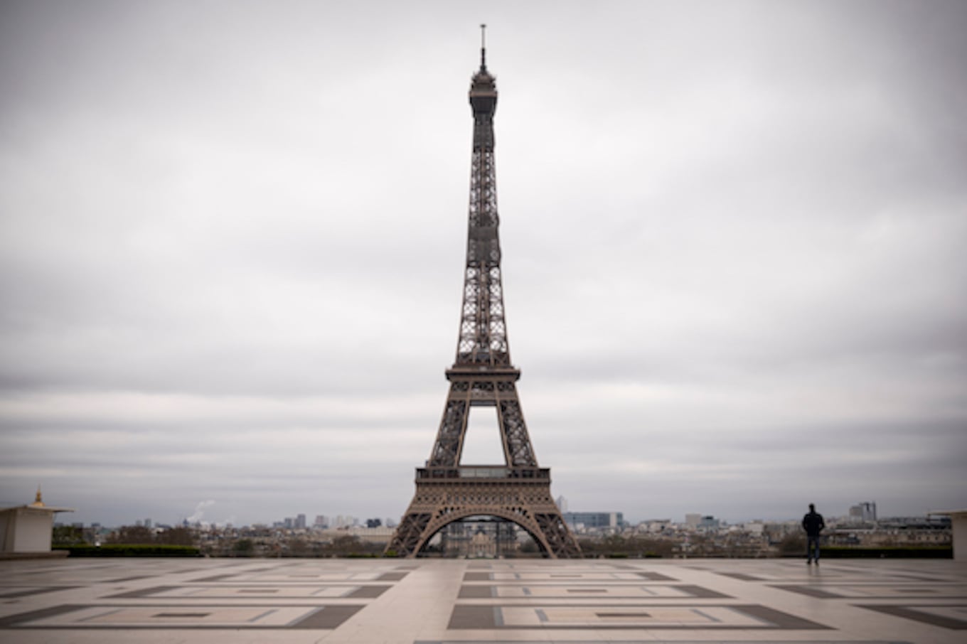 Un hombre camina en la desierta plaza de Trocadero frente a la Torre Eiffel, en el quinto día de un estricto bloqueo nacional que busca detener la propagación de la infección por COVID-19.FOTO:AFP