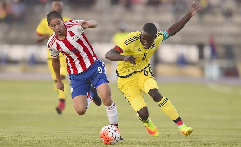 Pedro Báez de Paraguay y Kevin Balanta de Colombia, lidian por el balón. AFP