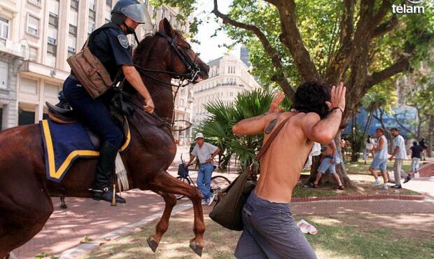 
Un policía castiga con bastón de goma a un joven manifestante. La represión dejó 30 muertos. Ocurrió en diciembre del 2001.
