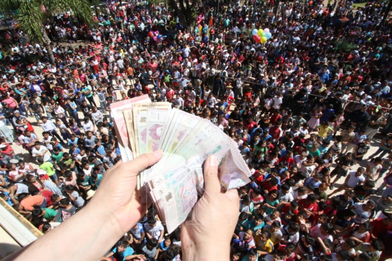 Los promeseros preparan los billetes para lanzar. Foto: Néstor Soto.