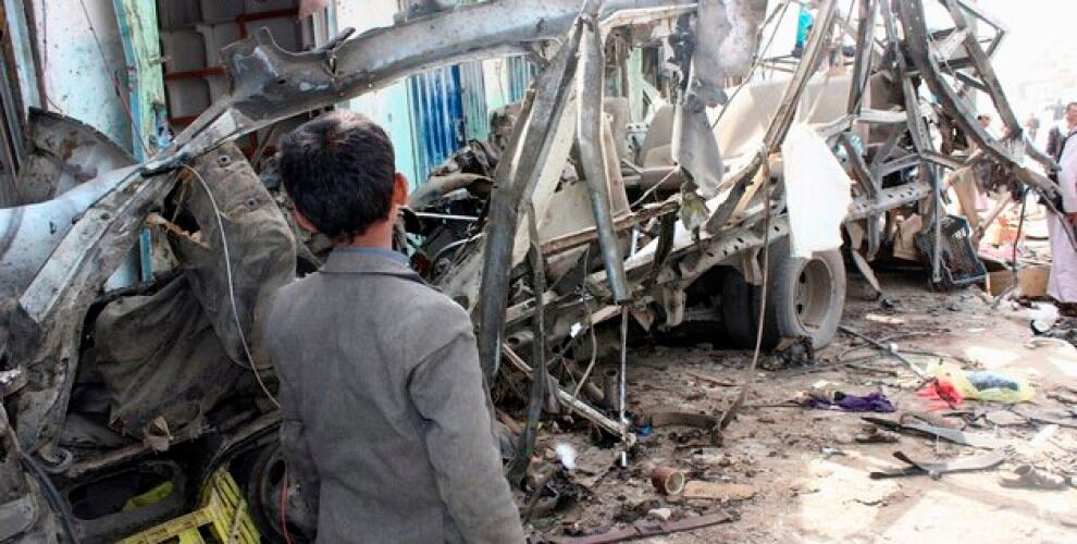Un niño yemení está de pie junto al autobús destruido en el lugar de un ataque aéreo de la coalición liderado por Arabia Saudita, que atacó el mercado Dahyan el día anterior en la provincia de Saada, bastión de los rebeldes Huthi, el 10 de agosto de 2018. - Un ataque en un autobús en un mercado en el norte de Yemen, controlado por los rebeldes, murieron al menos 29 niños el jueves, dijo la Cruz Roja, mientras la coalición liderada por Arabia Saudita enfrentaba una creciente protesta por la huelga. Foto: STRINGER / AFP / Getty Images.