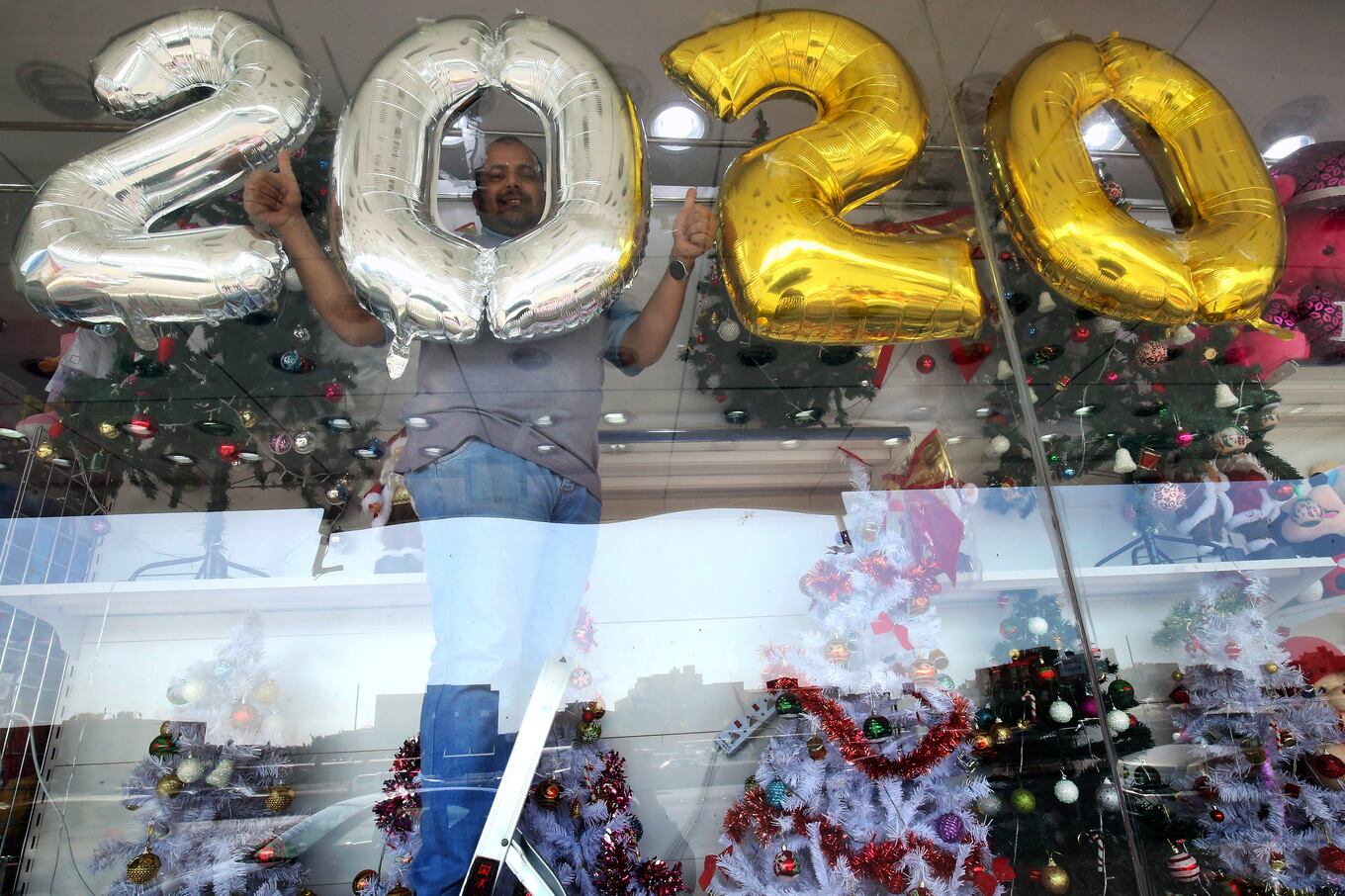 Un vendedor decora su tienda de regalos antes de la víspera de Año Nuevo en la ciudad de Kuwait el 31 de diciembre de 2019. Foto: de YASSER AL-ZAYYAT / AFP.