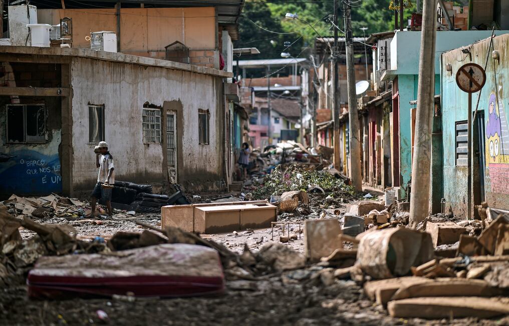 Un residente local camina entre los escombros tras el desbordamiento del arroyo Da Prata debido a las lluvias torrenciales, en Raposos, región metropolitana de Belo Horizonte, estado de Minas Gerais, Brasil, el 28 de enero de 2020. - El número de muertos por días de tormentas intensas e inundaciones en el sureste de Brasil aumentó a 45, mientras que el número de heridos se situó en 12 y el de desaparecidos se redujo de 25 a 19, dijeron funcionarios locales de Defensa Civil. Foto: DOUGLAS MAGNO / AFP.