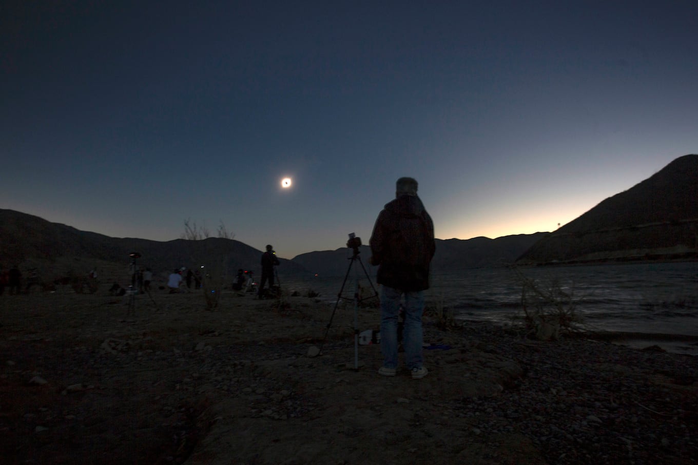 People watch the solar eclipse, from Puclaro, Coquimbo Region, Chile, on July 02, 2019. - Tens of thousands of tourists braced Tuesday for a rare total solar eclipse that was expected to turn day into night along a large swath of Latin America's southern cone, including much of Chile and Argentina. (Photo by CLAUDIO REYES / AFP)
