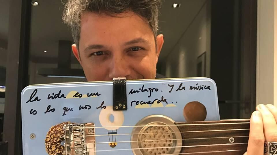 Alejandro Sanz exhibe la guitarra autobiografiada.