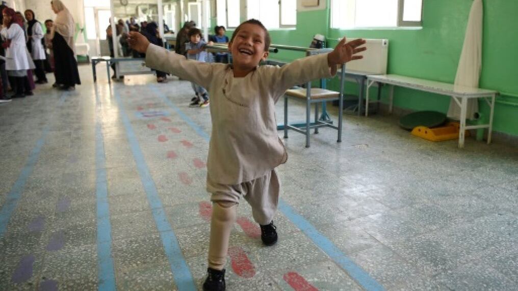 El pequeño Ahmad baila con soltura en un centro ortopédico de la Cruz Roja en la capital afgana, mientras personal médico y otros pacientes lo alientan en su danza.