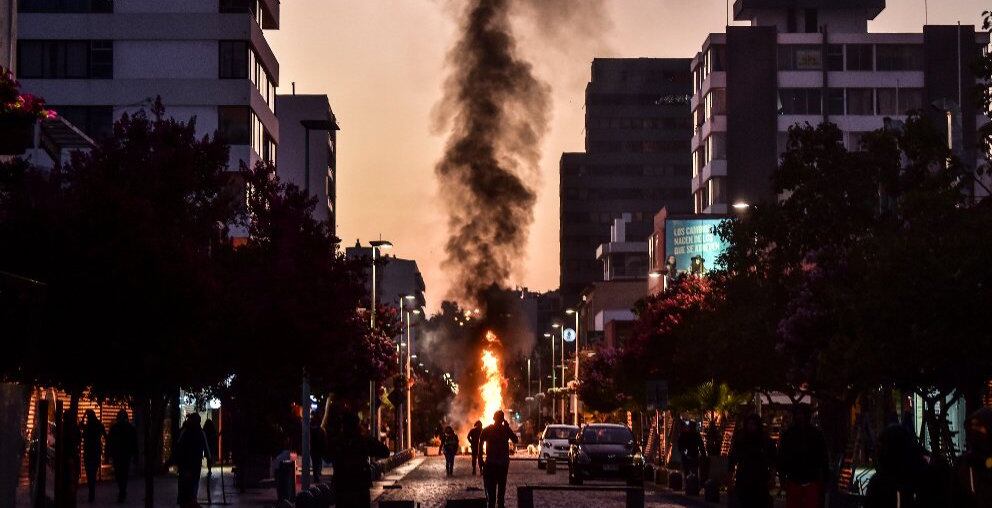 Al menos ocho vehículos fueron quemados y 23 policías quedaron heridos en Viña del Mar, en medio de violentos enfrentamientos en contra de la realización del festival de música popular que cada año se realiza en este balneario cercano a Santiago. Foto: AFP.