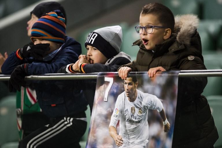 Para alegría de estos pequeños fans, CR7 jugará durante cinco años más en el Real. Foto: AFP.