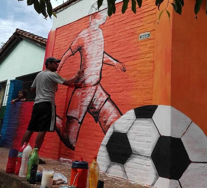 Sergio Jara Mendieta pintando uno de sus murales en Quiindy. Foto Gentileza.
