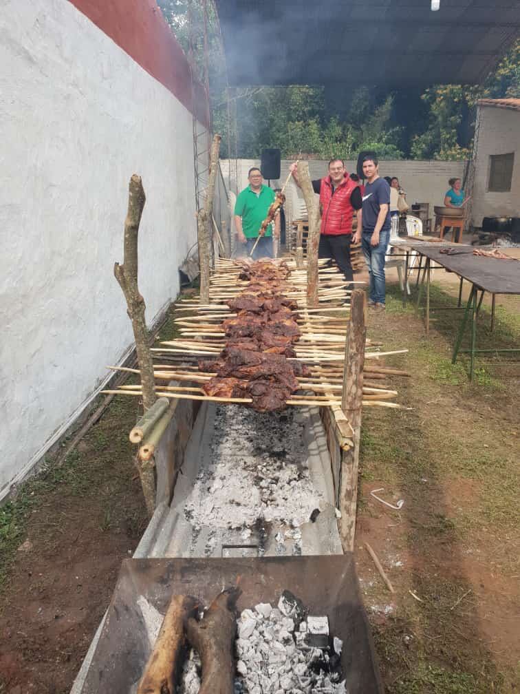 El cónsul (remera verde), representando al país en un asado junto con el diputado Tomás Rivas (chaleco rojo). Foto: Gentileza.