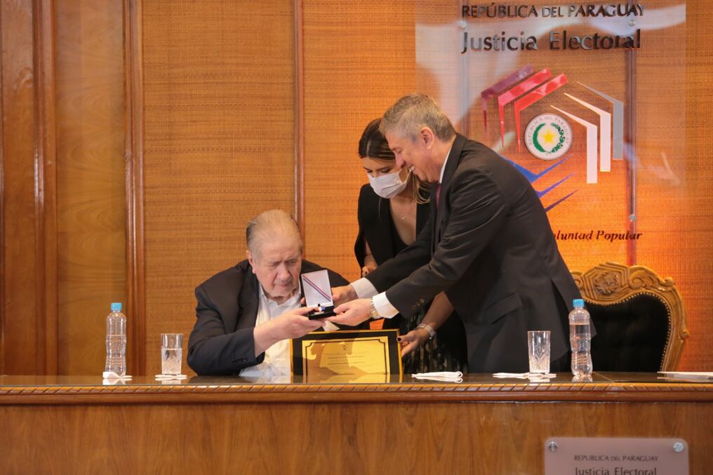 El ministro Alberto Ramírez Zambonini recibe el reconocimiento por parte del presidente del TSJE Jaime Bestard. Foto: Gentileza.