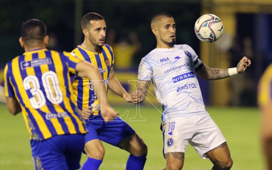 Víctor Ayala de Sol busca salir de la férrea marcación de Marcelo Palau y Walter Ortiz, en el partidazo que se vivió en Luque.FOTO:NÉSTOR SOTO