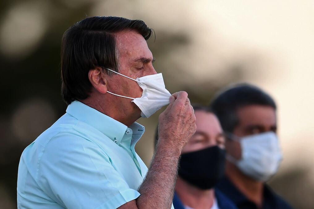 ¿Se quita el tapaboca? Bolsonaro camina hacia sus partidarios en el jardín del Palacio Alvorada en Brasilia, el 22 de julio pasado. Foto: AFP.