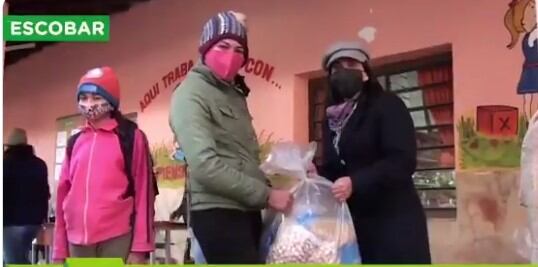 Con rostros sonrientes las madres se acercaron a retirar bolsas repletas de mercaderías. Foto: Captura de pantalla.