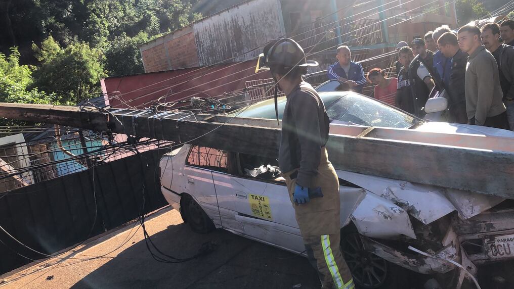 Así quedó el taxi tras impactar contra una columna de la Ande en el barrio San Agustín de Ciudad del Este. El acompañante del conductor falleció y el conductor, hijo del fallecido, resultó herido. Un motociclista también fue impactado y quedó herido. Foto: Gentileza.