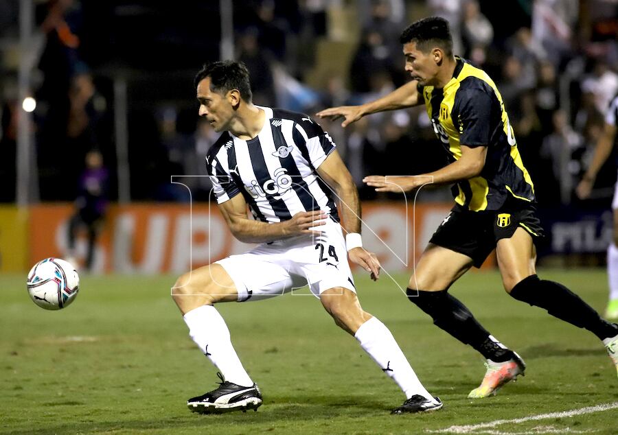 En acción Roque Santa Cruz, quien intenta eludir la férrea marca del defensor Marcos Cáceres, de Guaraní.FOTO:ROBERTO ZARZA